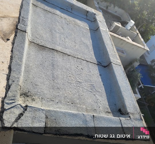 גג שטוח עם איטום ביטומני וסדקים קטנים